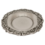 Descanso de garrafa em prata portuguesa com borda repuxada e cinzelada com folhagens e volutas. Contraste do Porto Javali e marca de prateiro desgastada. 13.5 cm. 75 gramas. 