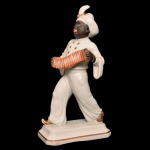 Estatueta em porcelana alemã policromada representando músico tocando pequena sanfona. Base retangular chanfrada. No verso, marca de Rosenthal da manufatura de Selb (Bavária). 19 x 9 cm.