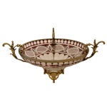 Grande centro de mesa em cristal, de formato circular, decorado com estilizações geométricas e ornamentado por montagem em metal dourado com alças laterais e base lavrada. 24 x 36,5 cm (sem o bronze).