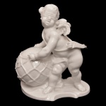 Estatueta em porcelana alemã de cor branca representando cúpido capturando o planeta Terra, alegoria do amor todo poderoso. No verso, marca da manufatura de Nymphenburg (Baviera). 10,5 x 8 cm.