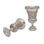Par de vasos com pé em prata brasileira, de formato abaulado e bojo em corneta, repuxados com gomos e cinzelados com folhagens. Contrates do teor 833 e marcas do prateiro A.V. 33 cm. 1k 900 gramas. Apresenta alguns amassados.