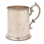 Caneca em prata inglesa repuxada e cinzelada, de formato cilíndrico, ornada com folhagens gravadas centralizando reserva à frente. Alça lavrada em volutas e bordas peroladas. Contrastes de Londres de 1867, marca dos prateiros Edward & John Barnard, chancela de Rowlands & Frazer  146, Regent Street  London.  10 x 11 cm. 226 gramas
