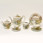 Serviço para chá e bolo de porcelana japonesa. Decoração com paisagem com montanhas e casario, predominando a cor verde. No verso as inscrições Fleet Wood China Hand Painter Japan. Constando de 24 peças, sendo: 01 bule de chá (19 x 24 x 13 cm),  01 açucareiro (15 x 16 x 10 cm), 01 cremeira (9.5 x 12.5 x 9 cm), 08 pratos para bolo (19 cm), 08 xícaras com pires p/ chá, 05 xícaras com pires p/ café.