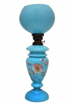 Lamparina em opalina francesa de tonalidade azul turquesa. Decorada com motivos florais em policromia de esmaltes. Cúpula esférica e guarnições em metal. Europa. C. 1900. 51 x 21 cm.