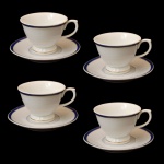 Conjunto de quatro xícaras com pires de porcelana nacional Schimdt. Fundo de superfície branca, com friso em dourado e azul cobalto.  5 cm (xícara). 11 cm (pires).