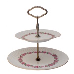 Doceira ou biscoiteira de porcelana Limoges. Dois pratos superpostos em porcelana, ornados por guirlandas floridas e reunidos por haste em metal dourado rematada ao topo por argola. França. Séc. XX. 26 cm. 26.5 cm (prato maior). 19 cm (prato menor) (19 cm) cm).