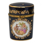 Caixa em porcelana francesa policromada, azul noturno. Formato cilíndrico com detalhes em dourado e representação de cena galante. No fundo as inscrições: Limoges, France. Séc. XX. 11,5 x 8 x 5,5 cm.