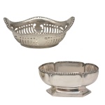 Lote constando de dois saleiros em prata, sendo: A) formato oval, com decoração fenestrada, centralizada por emblema liso e bordas onduladas. 3 x 7 x 4 cm. B) Arredondado com recortes e relevo, assentado sobre base sextavada. Ambos, com acabamento perolado. 3,5 x 8,5 x 6 cm. 36 gramas.