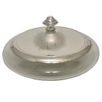 Compoteira circular em cristal com tampa abobadada em prata inglesa lisa, ornamentada por discretos filetes e encimada por pega em pião. Contraste da prata inglesa do final do séc. XIX-início do séc. e marca de prateiro desgastada. 9 x 15 cm.