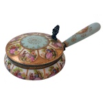 Pequena panela com tampa, em porcelana alemã, ornamentada por reservas com cenas românticas policromadas sobre fundo dourado. Tampa com descanso de polegar. No verso, marca da manufatura de Dresden. 6,5 x 25 x 14 cm.