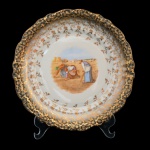 Prato em porcelana alemã Winterling Bavária, com representação da pintura original de Jean-François Millet, da Escola Realista de Barbizon, intitulada Les Glaneuses (As Respigadoras) de 1857. Detalhes em dourado sobre fundos branco e preto na borda, sendo essa recortada. 26 cm.