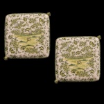 Par de bases de porcelana policromada predominando a cor verde. Formado de almofadas quadrangulares com dois pés laterais. No verso marcas da manufatura Luiz Salvador, Itaipava, RJ. 15 x 42 cm. UMA NO ESTADO (RESTAURADA).