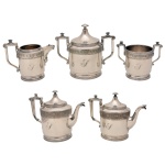 Reed & Barton - Conjunto americano para chá e café em metal espessurado a prata, encimados com frisos de decoração mourisca, em relevo, e alças geometrizadas, finalizadas em voluta. Pegas em pião e bicos fitomorfos. Bordas e bases em filetes paralelos. Contrastes: MF’D & PLATED BY REED & BARTON. Símbolo para data, posterior aos anos 1957. Números 2940 – 6. 2ª. metade do séc. XX. Constando de bule p/ café (20 x 25 cm), bule p/ chá (18 x 24 cm), leiteira (13 x 16 cm), açucareiro com tampa (17 x 19 cm) e biscoteira (11 x 14 cm). 
