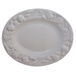 Grande travessa de cerâmica italiana na cor branca monocromática decorada com frutas em relevo. No verso marcas da manufatura Antica Fornace. Ceramiche da Tavola. Made in Italy. 44 x 36 cm.