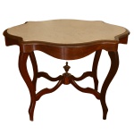 Mesa de centro brasileira estilo Louis Philippe, com tampo retangular recortado em mármore. Saia abaulada lisa, apoiada em pernas curvilíneas reunidas à base por traves entrecruzadas com pequeno adorno no formato de urna. Séc. XIX. 74 x 107 x 77 cm.