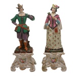 Par de estatuetas de porcelana europeia. Figura masculina sem mão direita. 36 cm. Necessita de restauro. 