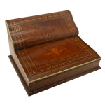 "Bureau de voyage" francesa, monogramada, de formato retangular com tampo reclinável, revestida em couro pirogravado. Parte interna com seis acessórios em prata e marfim entre eles, sinete (com monograma), régua e abridor de cartas, acompanhados de par de tinteiros em cristal.  Excelente estado de conservação. Plaqueta de identificação do fabricante P. Sormani  114, Rue du Temple  Paris. Séc. XIX. 20 x 40 x 34 cm.