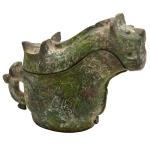 Vaso ritual chinês em bronze, para vinho, no formato de tigre, ornamentado por adornos geométricos estilizados e gravados. Corpo bojudo encimado por tampa com cabeça .Atribuído a dinastia Shang (c. 16001046 a. C.). 20  x 15 x 6 cm. Exemplar semelhante no Museu em Londres.