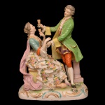 Estatueta em porcelana francesa policromada representando casal de aristocratas brindando. Manufatura de Samson. Séc. XIX. 20 x 12 cm.