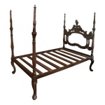 Cama estilo D. José em jacarandá com cabeceira esculpida e vazada centralizando medalhão. Colunas laterais torneadas e pernas recurvas rematadas por garras. Séc. XIX. 186 x 129 x 204 cm.