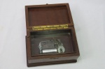 Antiga caixa de música de madeira, fabricada na Suíça. Necessita regular o botão de pausa da música quando de fecha a tampa. Mede  16 x 11  x 8,5 centímetros e está funcionando.