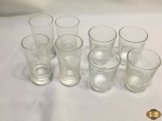 Jogo de 8 copos de aperitivo em vidro, sendo 4 com 8,5cm de altura e 4 com 6,5cm de altura.