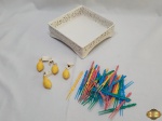 Lote composto de salva quadrada em porcelana vazada, diversos garfos de petisco e 4 pregadores com enfeite de limão. Medindo a salva 18cm x 18cm x 6cm de altura.
