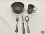 Lote composto de 3 colheres, caneca e cumbuca infantis em prata 90. Necessita de limpeza.