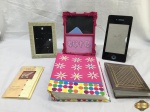 Lote diverso, composto de 3 porta retratos em materiais e modelos diversos, 2 álbuns fotográficos e 1 envelope decorado para carta. Medindo o álbum rosa 25,5cm x 19cm.