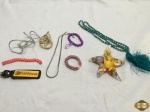 Lote de bijuterias, sendo 2 colares de diferentes modelos , 2 pulseiras e 1 prendedor de cabelo em forma de estrela.