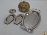 Lote composto de pequena bandeja, 2 cinzeiros, açucareiro e tampa em metal prateado. Medindo a bandeja 24,5cm x 13,5cm. O açucareiro está com desgaste no banho.