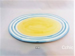 Travessa ovalada pintada nas cores azul e amarela, marcado Hausen Ware. Apresenta pequenos bicados. Medida: 41x30cm de comprimento.