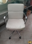 Cadeira de escritório em couro sintético branco, com rodizio e braços em aço. Medindo 52cm x 42cm x 87cm de altura do encosto.