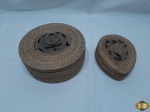 2 caixas em palhinha trançada com fundo e tampa em madeira, sendo a tampa entalhada. Medindo a redonda 17,5cm de diâmetro x 7cm de altura, o entalhe da tampa da redonda está quebrado, necessitando de colagem.