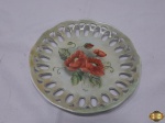 Prato decorativo em porcelana vazada com pintura floral. Medindo 19,5cm de diâmetro.