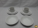 2 xícaras de chocolate com pires, 2 pratos de bolo e 2 bowls em porcelana branca canelada.