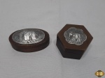 Lote de 2 caixas em madeira com relevo de elefante sob placa em metal na tampa. Medindo a facetada 6,5cm de diâmetro x 4,5cm de altura.
