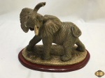 Escultura de elefante em resina africana. Medindo 21cm de comprimento x 19,5cm de altura. Falta um dos dentes.