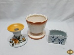 Lote composto de cachepot em porcelana, castiçal em porcelana e porta treco em porcelana. Medindo o cachepot 13cm de altura x 13cm de diâmetro de boca. O castiçal possui um fio de cabelo na bobeche.