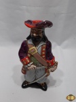 Garrafa licoreira em porcelana na forma de pirata. Medindo 24,5cm de altura. Com restauro na tampa.