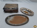 Lote composto de petisqueira gomada, salva oval com borda perolada e caixa retangular com interior em madeira. Todas as peças em prata 90 com desgaste no banho. Medindo a caixa 16,5cm x 11cm x 7cm de altura, a tampa da caixa está solta.