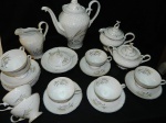 Aparelho de chá e café em porcelana branca  SCHMIDT decorada com flores e trigos  composto de : 1 bule ,  2  leiteiras ,1 açucareiro, 1 mantegueira, 8 xicaras para chá com  pires total 21 peças