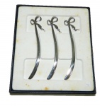 Três marcadores  em metal prateado no formato de espada de samurai  terminando com laço e bolinha perolada na caixa original  medindo 12 cm
