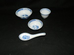 Quatro  peças em porcelana chinesa constando: 1 bowl med. 12 x 5 cm , 1 colher, 1 xícara para saquê e 1 pequeno bowl med. 9 x 4 cm
