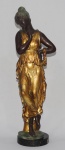 BEZ. Escultura de bronze patinado e dourado, na figura de jovem greco romana, sobre base circular de mármore. 65 cm altura. Assinada na base. Itália, séc. XX.
