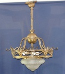 Lustre de metal dourado e vidro artístico, estilo império, para quatro luzes, decorado com cabeças de caprino interligadas por guirlandas. 61 x 92 cm altura. (Dois vidros no estado).