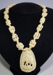Colar africano em marfim ou osso com figuras de elefantes. Med. 48 cm e pingente 5 x 4 cm.
