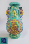 Raro vaso em porcelana chinesa FAHUA, com marcas da Dinastia Qing, período Qianlong (1735-1796), decorado com cães de fó em relevo nas reservas centrais. Olhos articulados. No Gargalo, figura de imortal voando sobre garça. borda virada RUYI, alças recortadas em mandalas sustentadas também por cães de fó. Moldado no forma de cebola e recoberto por esmaltes 4 cores. Superfície texturizada adornada com símbolos budistas auspiciosos, A borda superior é decorada com formas de fungos Lingzhi, e a borda inferior com nuvens estilizadas em uma superfície de onda texturizada. Med. 24 x 12 cm