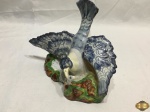 Escultura de ave caçando em porcelana pintada. Medindo 23,5cm de comprimento x 16,5cm de altura.