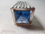 Anel de prata, em formato quadrado, com pedra azul. Aro 16.